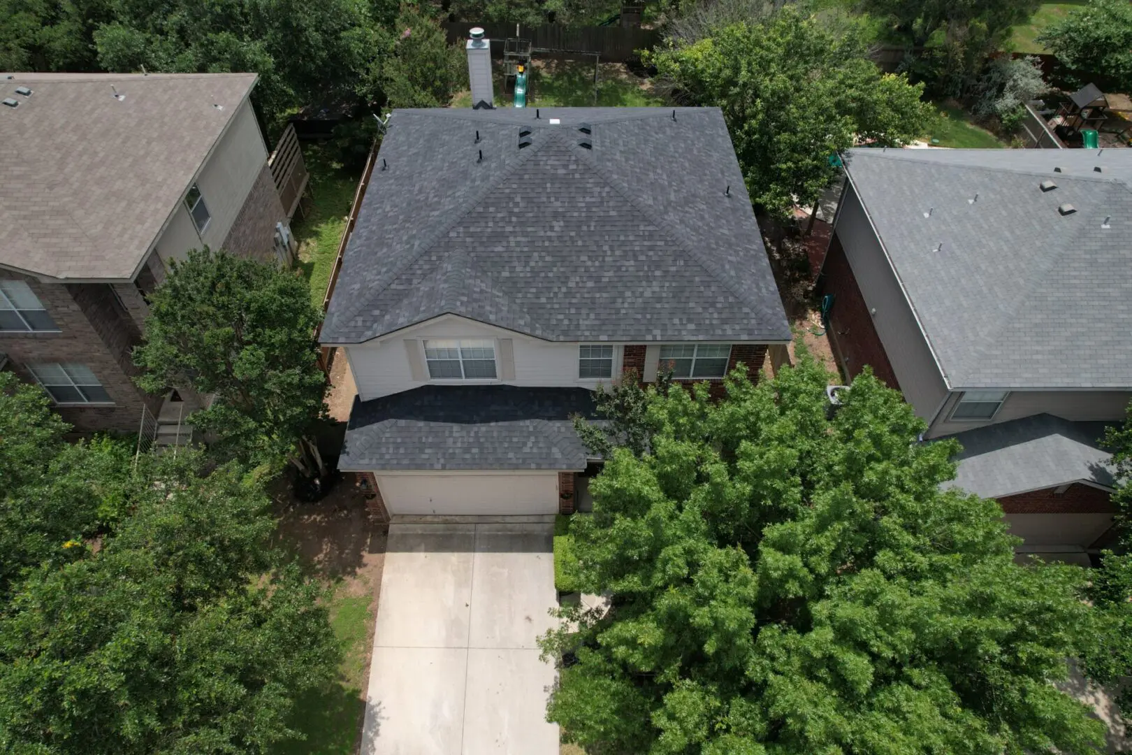 A house with a driveway and trees in the background