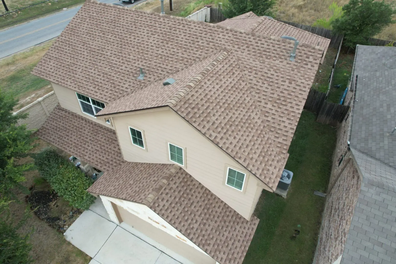 A house with brown shingles and green windows.