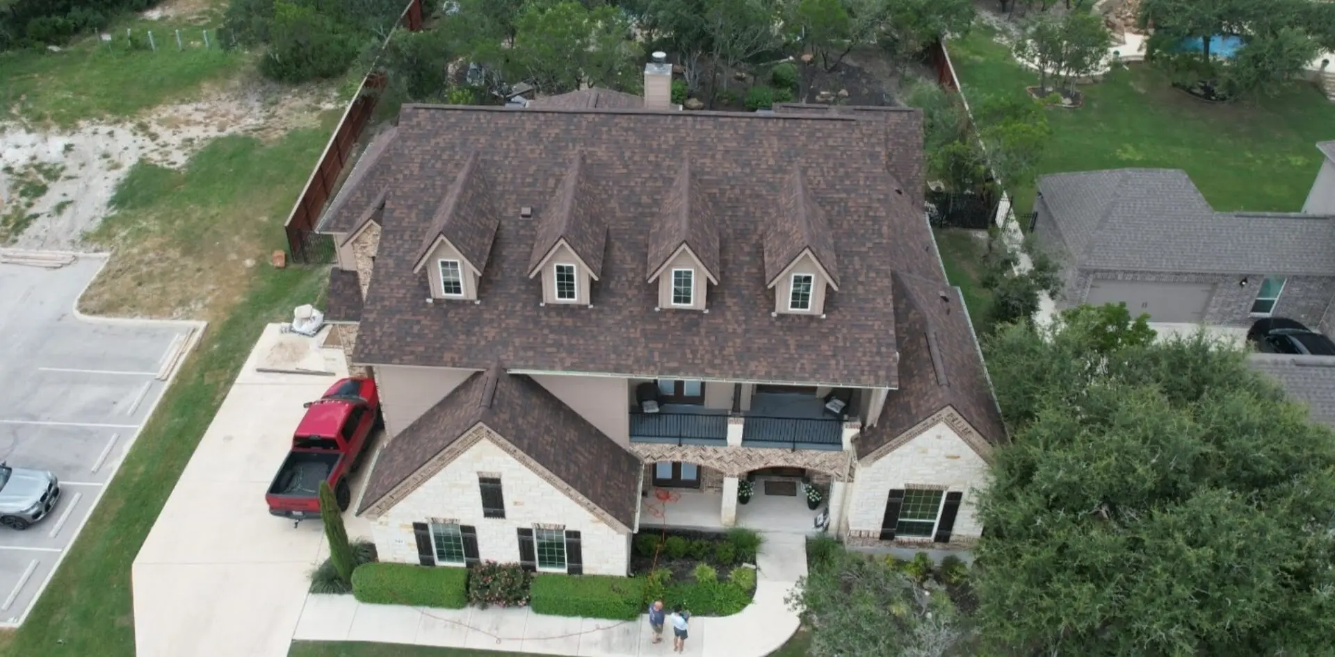 A large house with brown roof and white walls.