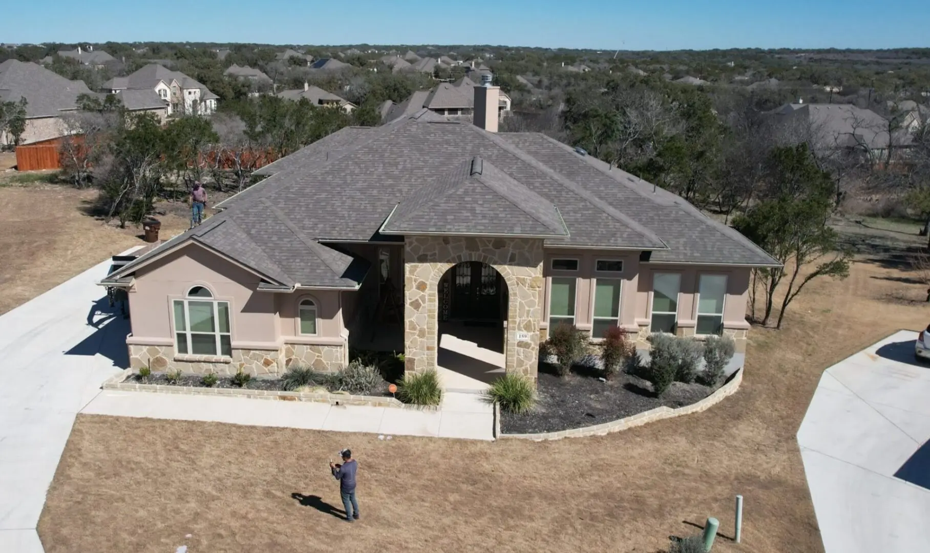 A man standing in front of a large house.