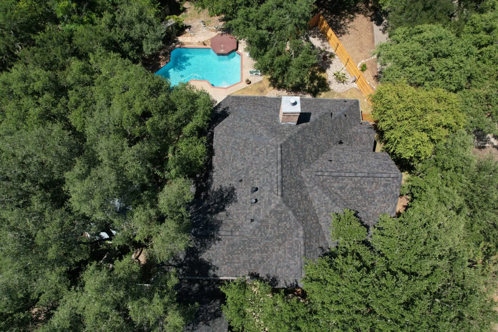 A house with a pool and trees in the background