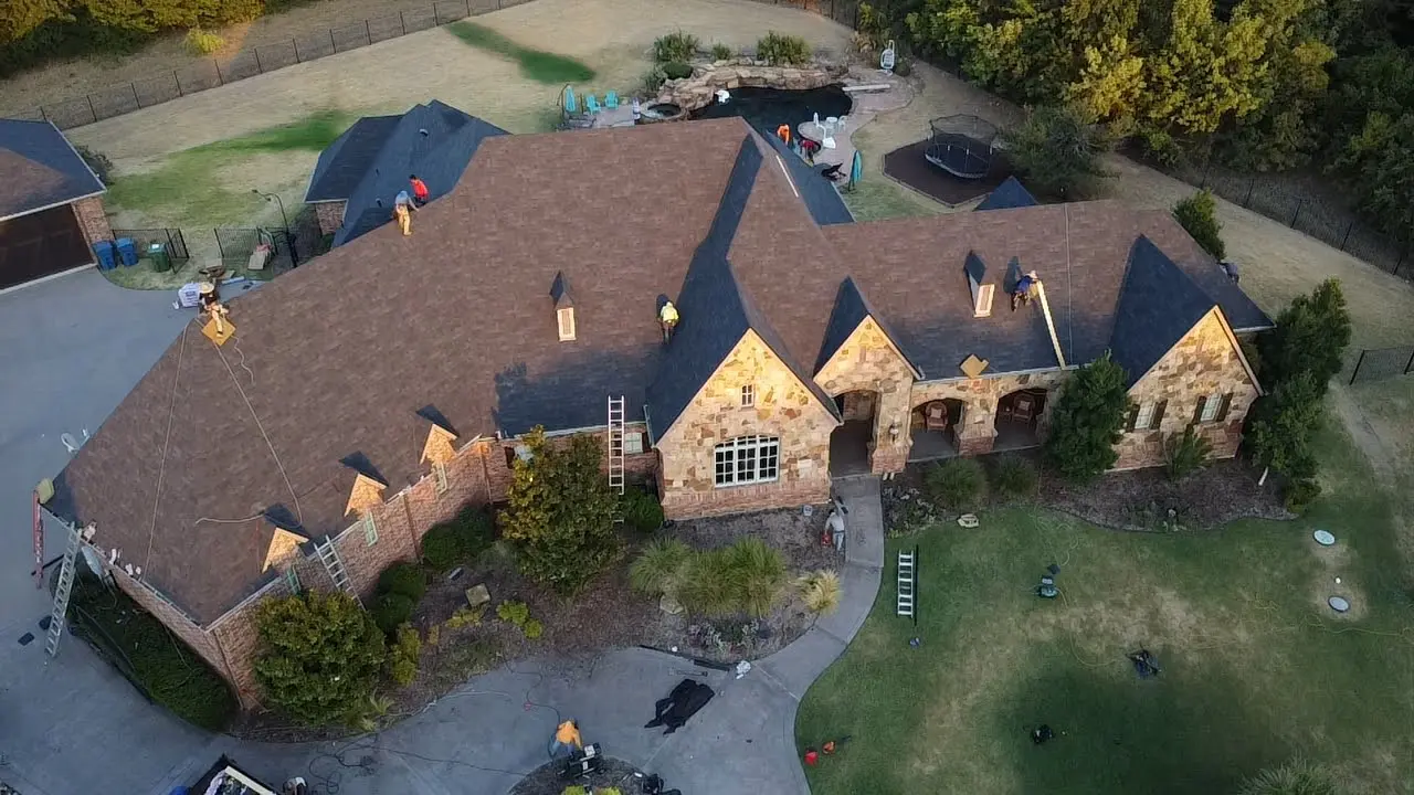 A large house with brown shingles and a driveway.