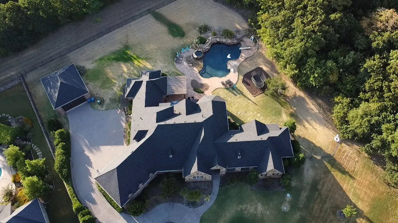 A large house with a pool and trees in the background