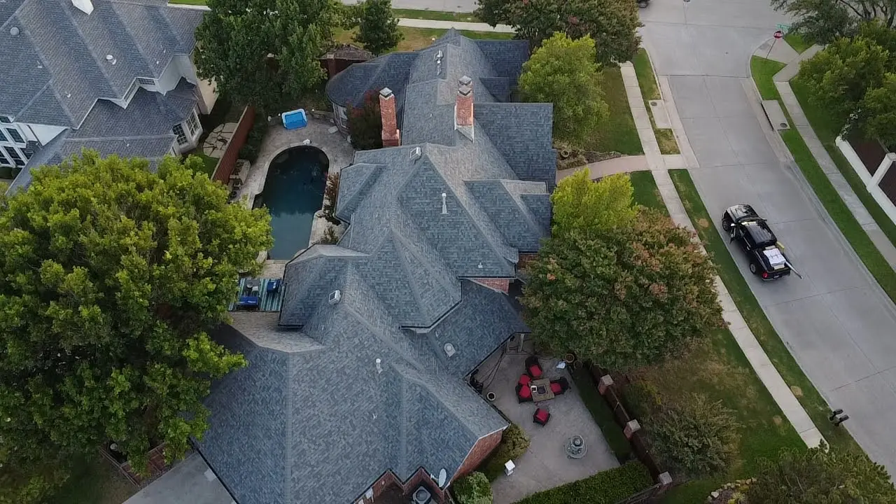 A bird 's eye view of a house with cars parked in front.