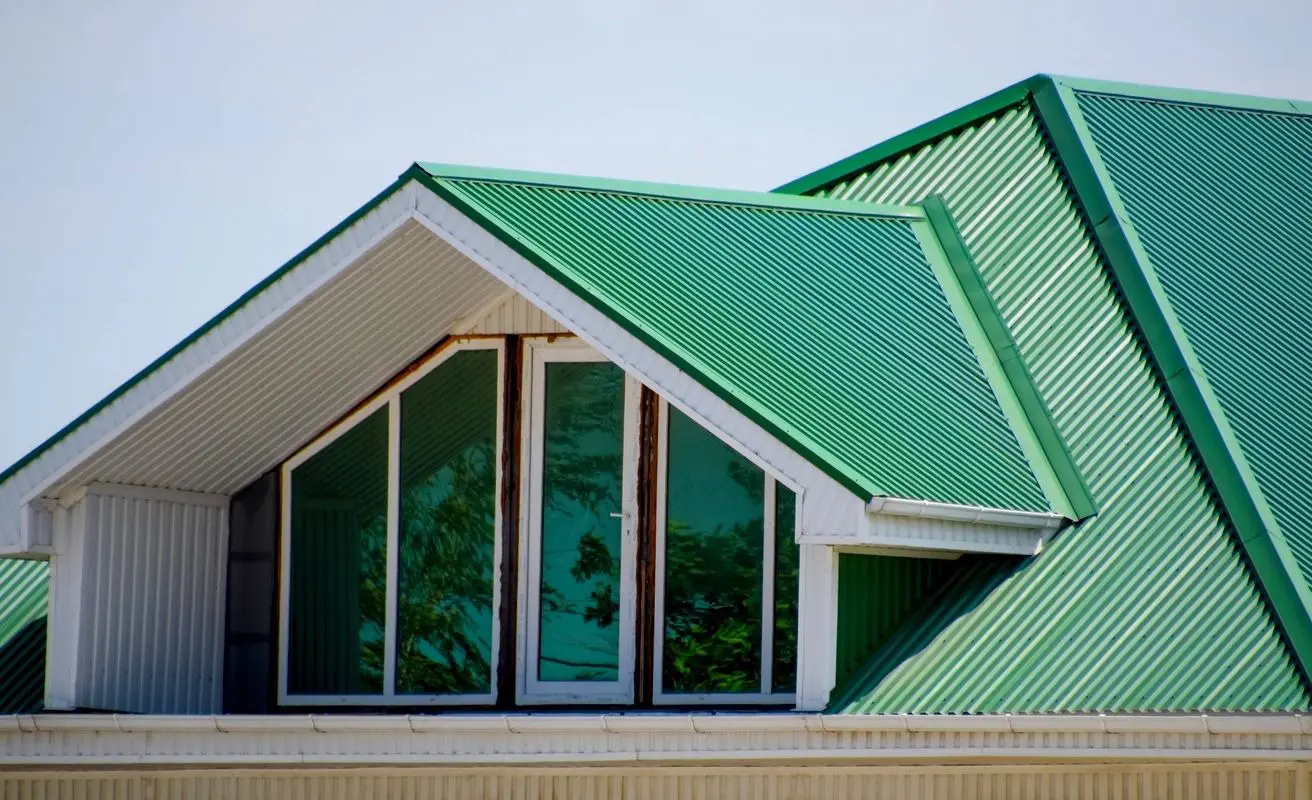 A green roof with windows and doors on top of it.