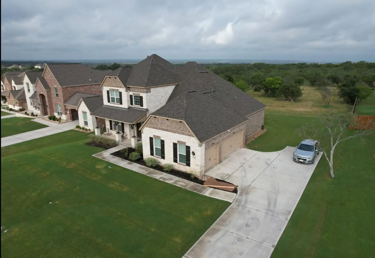 A car parked in front of a house on the grass.