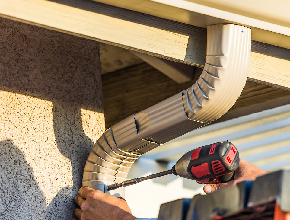 worker-attaching-aluminum-rain-gutter-and-down-image